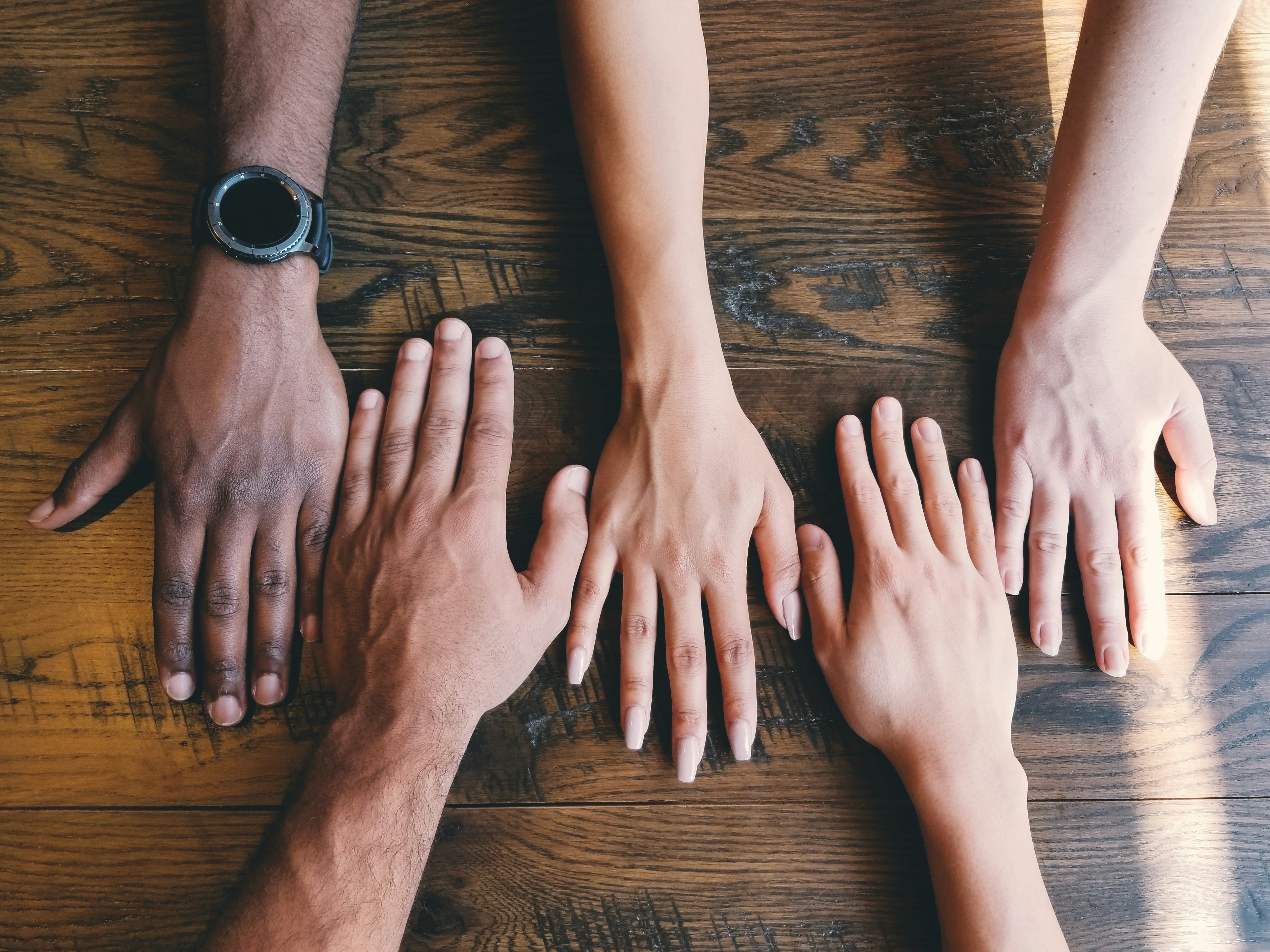 A group placing their hands on a shared table
